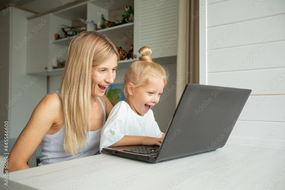 surprised mom and daughter sit at laptop at home surprised mom and daughter sit at laptop at home