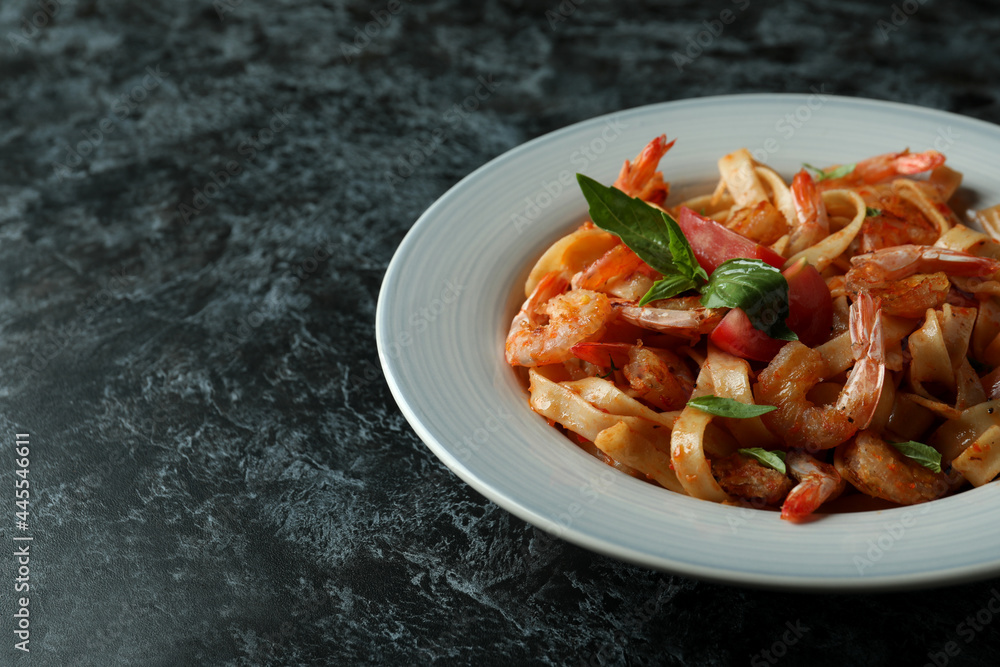 Concept of tasty eating with shrimp pasta on black smokey table Concept of tasty eating with shrimp pasta on black smokey table