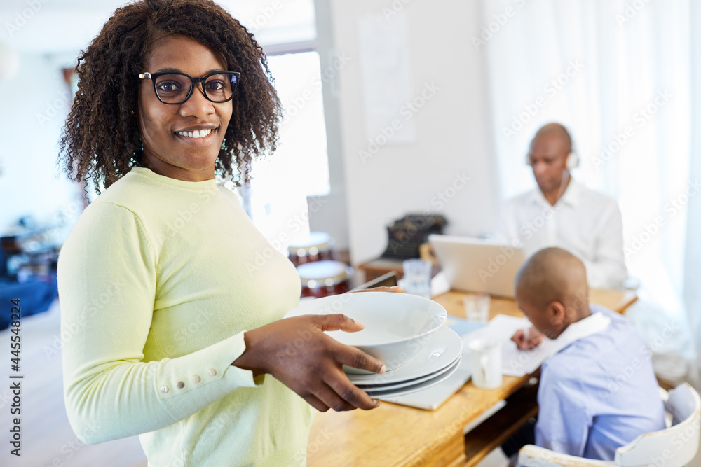 African American woman with dishes as a housewife in the home office