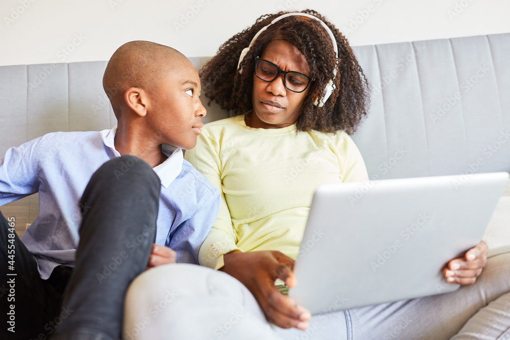 Fototapeta premium Mother and son on the sofa during video conference online