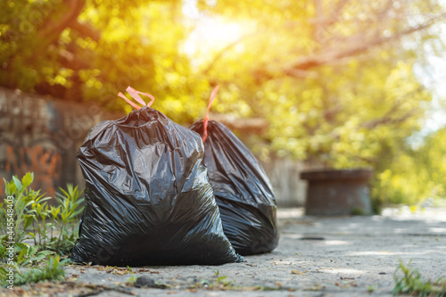 Foto full black garbage bags with trash at city park outdoor after clean up