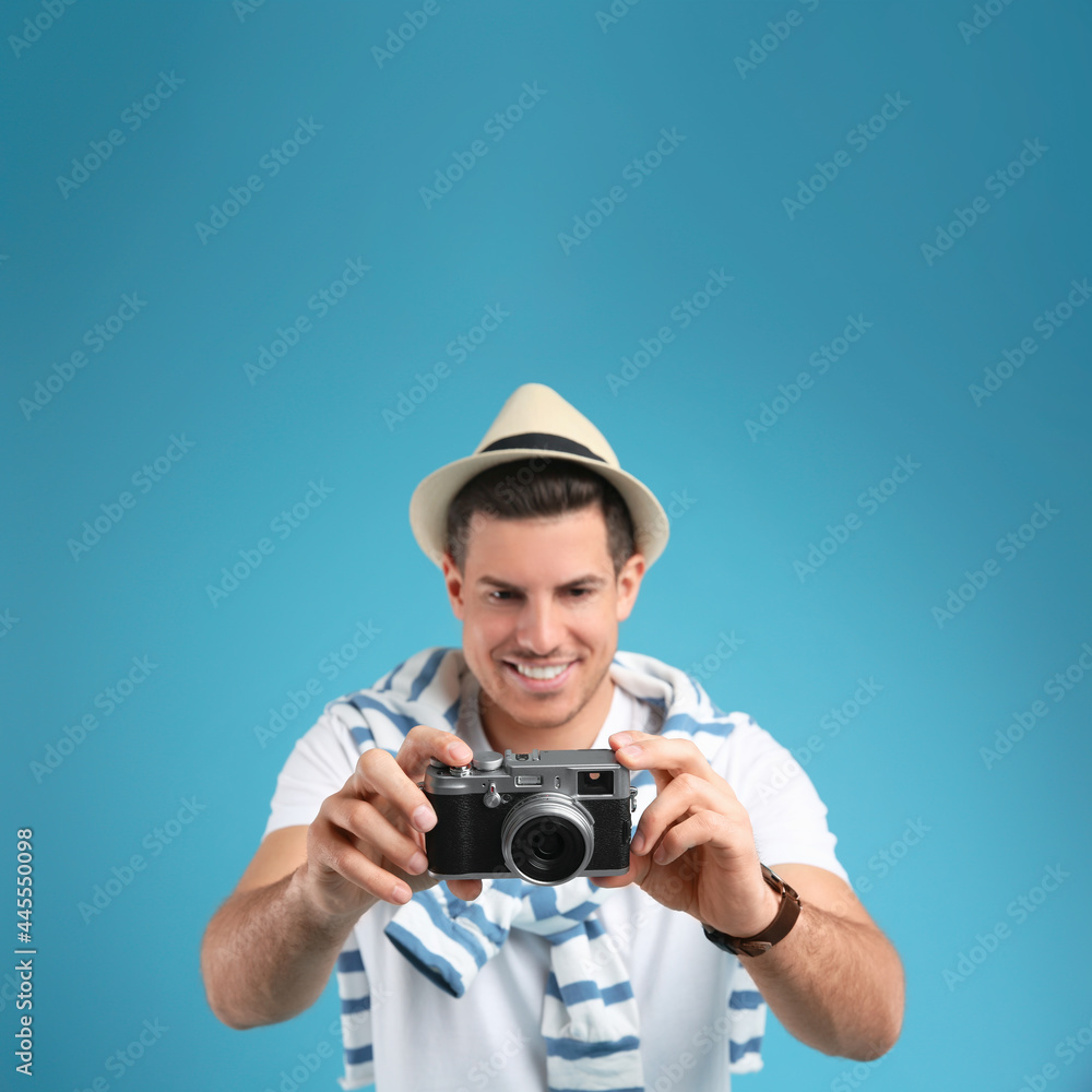 Obraz premium Male tourist taking picture against turquoise background, focus on camera