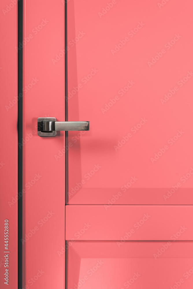 Stainless stylish door knob on pink wooden door
