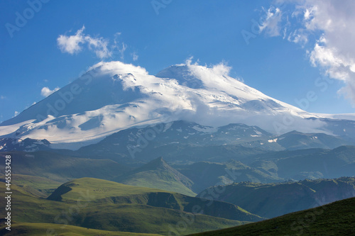 Mountain landscape. The Caucasus Mountains. Elbrus on the background of green hills. Blue sky. A summer day. Russia.