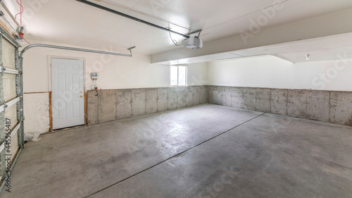 Pano Empty garage interior with concrete floors and an automatic door