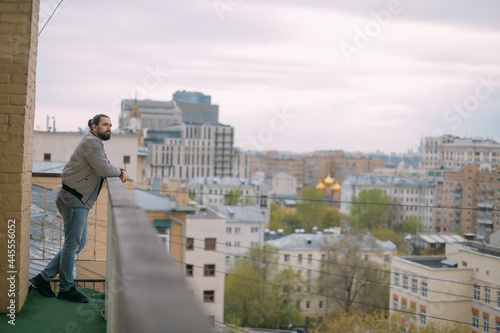 Portrait of a young handsome man on the balcony overlooking the city. City life.