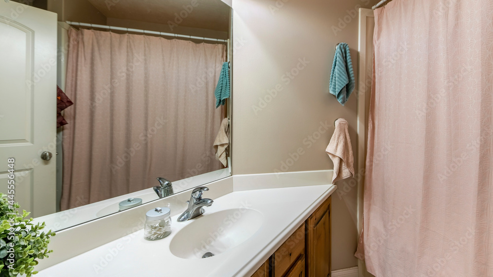 Pano Bathroom interior with closed light pink patterned curtain across the vanity sink with mirror Pano Bathroom interior with closed light pink patterned curtain across the vanity sink with mirror