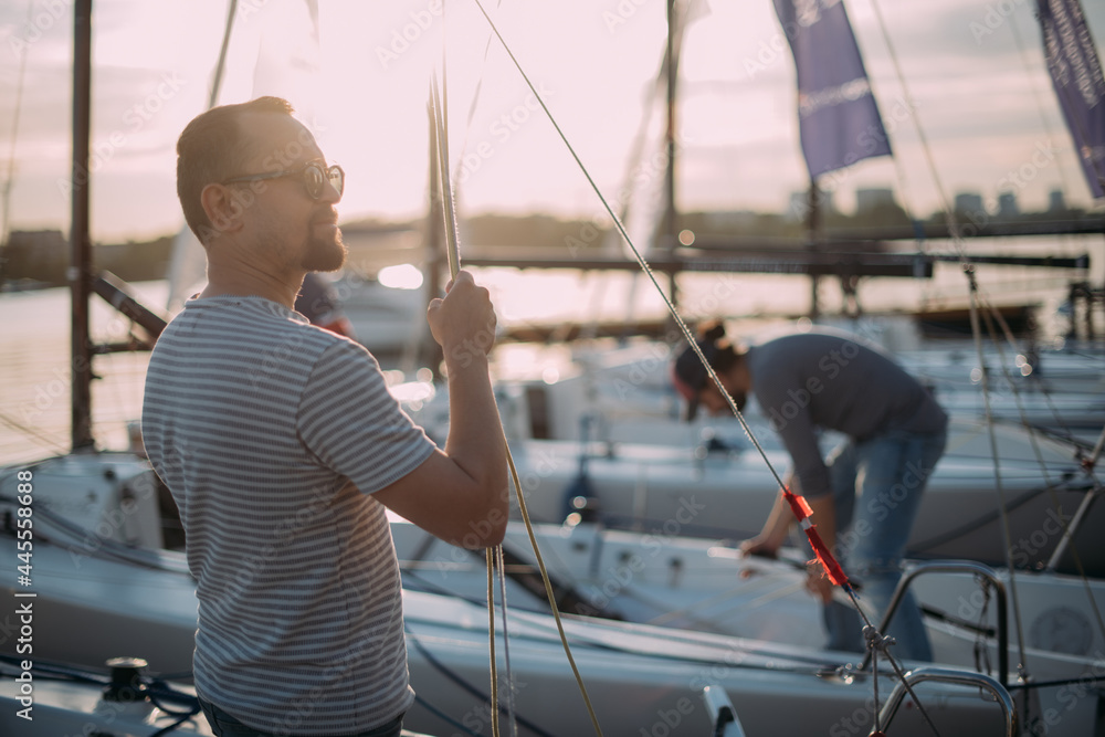 Tourist walks on sailing yachts. Male tourist on vacation on a boat at the sea.