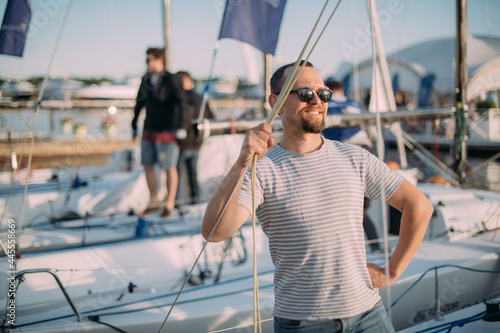 Tourist walks on sailing yachts. Male tourist on vacation on a boat at the sea.
