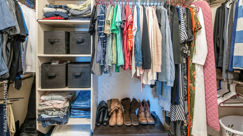 Pano Organized small walk in wardrobe with clothes and linen storage boxes