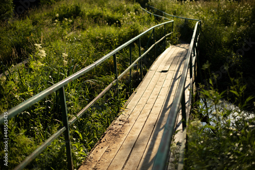 Small bridge over the river. Wooden platform across the swamp.