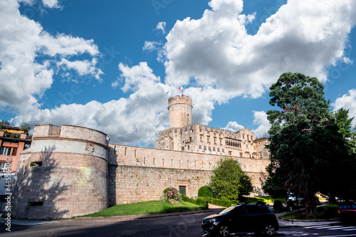 Trento, Italy, June 2021. The imposing Buonconsiglio castle, a three-quarter view from the road that runs along the walls. Beautiful summer day.