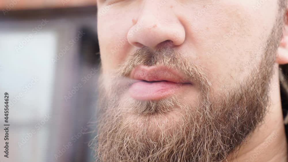 close-up. a man with a beard and dreadlocks smokes cigarettes and releases smoke close-up. a man with a beard and dreadlocks smokes cigarettes and releases smoke