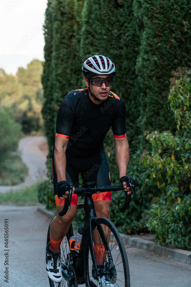 Obraz premium Young Caucasian cyclist riding a bicycle standing upright