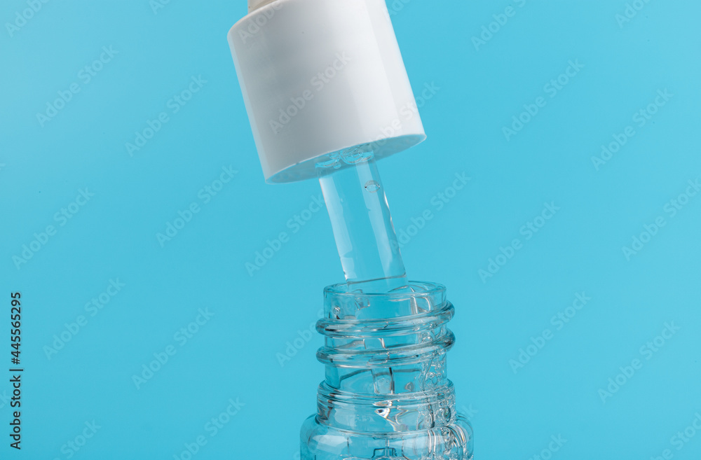 face serum drop with bottle on blue background. face serum drop with bottle on blue background.