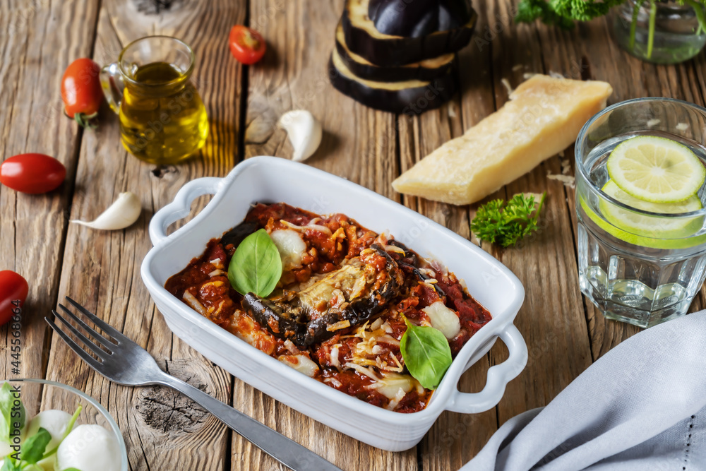 Parmigiana is Italian dish with eggplants, tomatoes sauce, garlic, basil and cheese