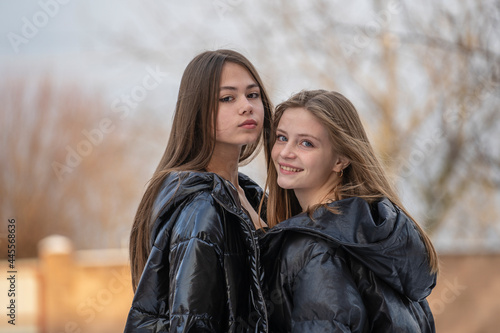 Portrait of two charming young girls, outdoors, close up