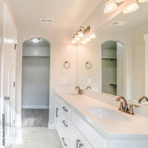 Square frame Interior of a white bathroom with shower with glass wall  sink and empty closet