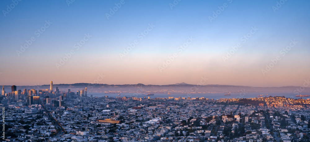 A picturesque panorama of the city of San Francisco at a bright beautiful sunset from Twin Peaks hill.