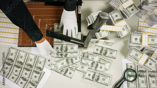 illegal manufactory of money, falsifier cutting banknotes on guillotine.