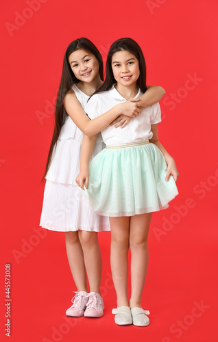 Cute Asian sisters on color...
