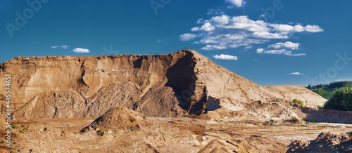 Mountain, hill of quarry and river sand, blue sky with white clouds. Dune, canyon, desert