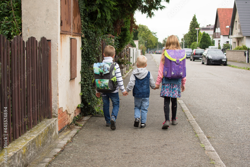 Obraz premium Thre children walking to school. First school day.