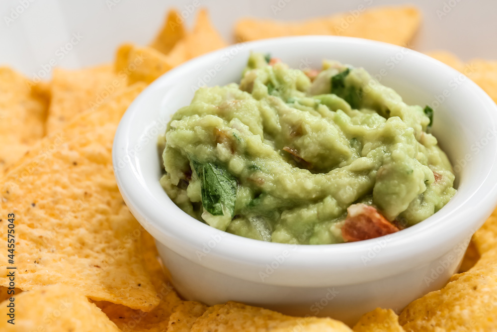 Bowl with tasty guacamole and nachos, closeup Bowl with tasty guacamole and nachos, closeup