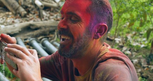 Photography Male with a painted face taking a photo at the Holi Hindu festival of Color in I