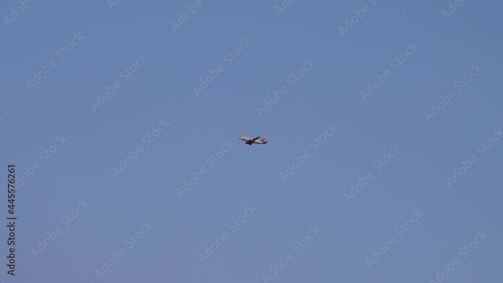 The plane with flashing beacons and released landing gear flies against the background of the evening blue sky. Bottom side view The plane with flashing beacons and released landing gear flies against the background of the evening blue sky. Bottom side view