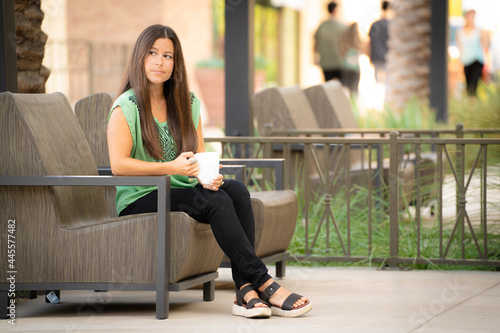 Beautiful Pretty Young Brunette Woman Break Up Waiting for Online Date Alone Depressed Lonely Solitude Expression Looking off Drinking Coffee Tea Outdoors Outside on at Mall Café Natural Soft Daylight photo