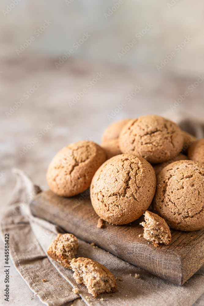 Oatmeal cookies on wooden cutting board, brown concrete background. Healthy snack or dessert. Oatmeal cookies on wooden cutting board, brown concrete background. Healthy snack or dessert.