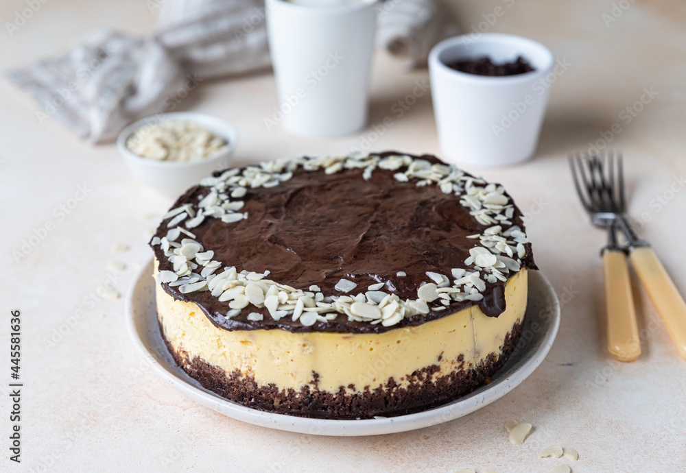 Delicious creamy cheesecake decorated with chocolate glaze and almond, light concrete background. No bake mousse dessert. Delicious creamy cheesecake decorated with chocolate glaze and almond, light concrete background. No bake mousse dessert.