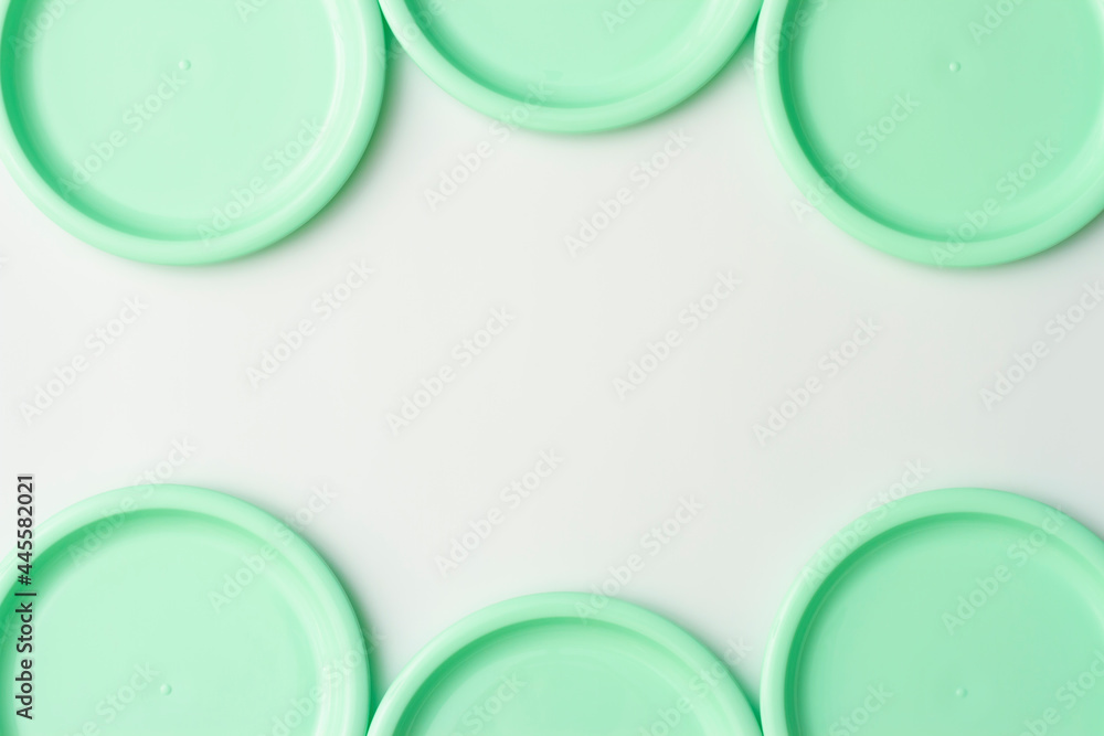 Plastic dishes in mint color on white background