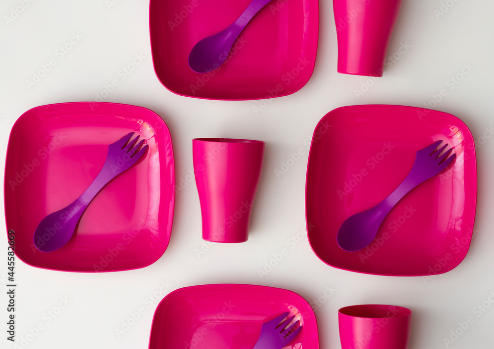 Purple plastic plates and forks with a spoon on a bluish background Purple plastic plates and forks with a spoon on a bluish background