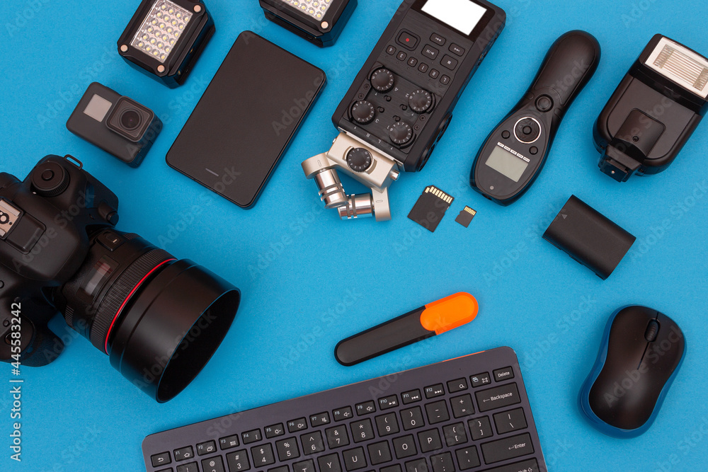 Top View of Photographer's, Videographer's or Video Blogger's Workplace. Digital Gadgets Lying on Blue Table - Flat Lay Top View of Photographer's, Videographer's or Video Blogger's Workplace. Digital Gadgets Lying on Blue Table - Flat Lay