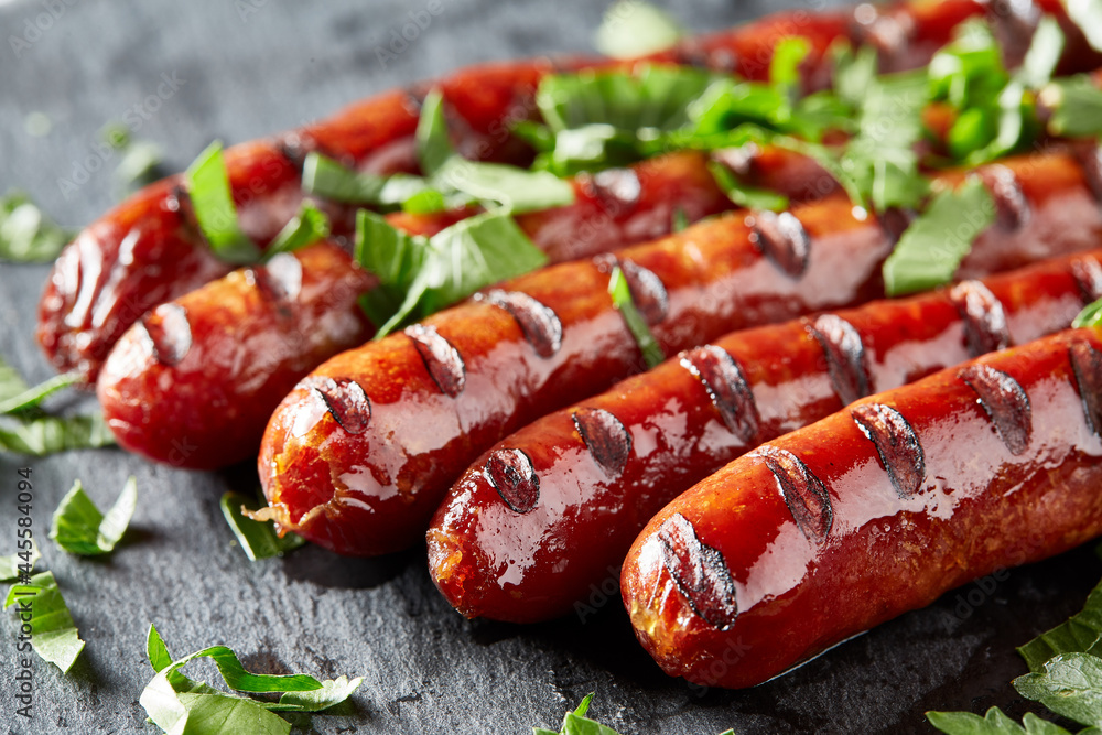 Grilling sausages on barbecue grill with greens Grilling sausages on barbecue grill with greens