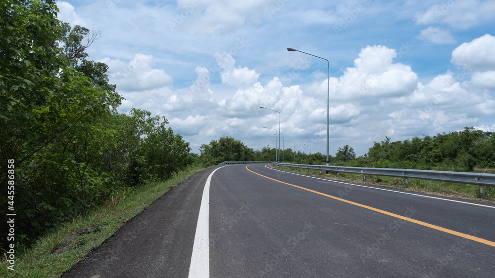 The road has a curve along the plane with trees on its side. The road has a curve along the plane with trees on its side.
