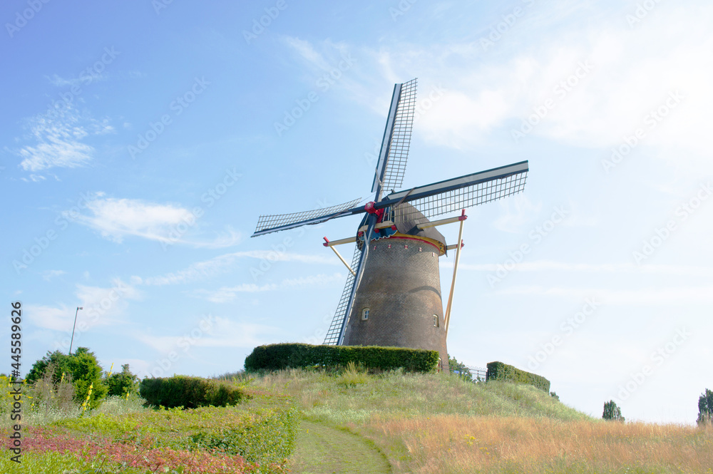 Traditional historic windmill on a green hill in the center of Wijchen in the Netherlands