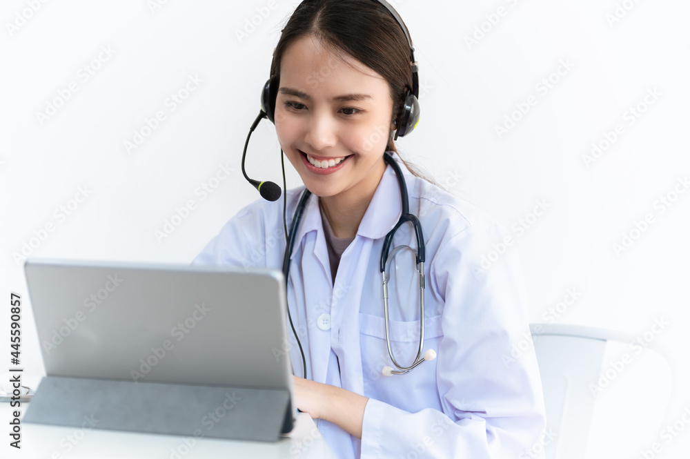 Portrait photo of young beautiful Asian doctor video remote conference call online with patient for social distancing due to covid-19 pandemic. Technology, health care new normal online telehealth.