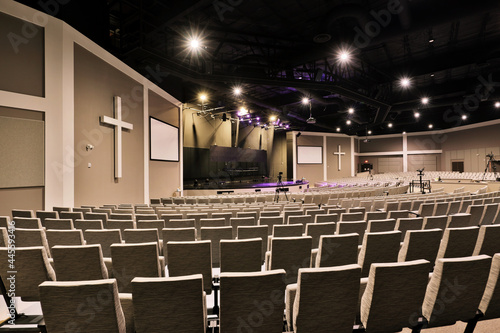 Empty interior of large church congregation sanctuary with stage and concert seating