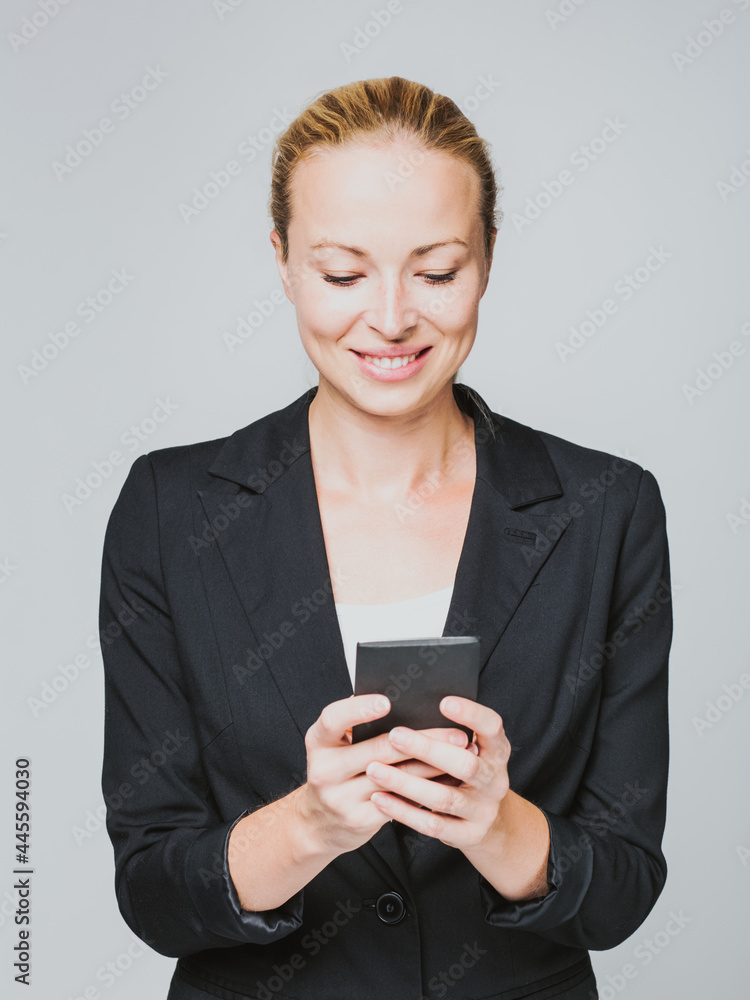 Beautiful young caucasian businesswoman using mobile phone. Beautiful young caucasian businesswoman using mobile phone.