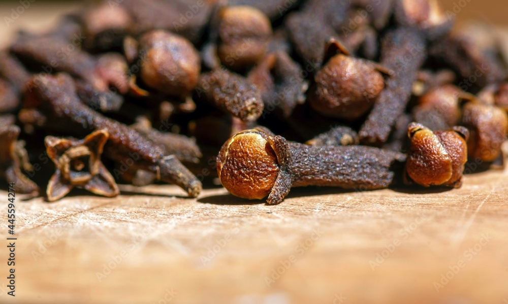 Dried clove seeds, in shallow focus, on the natural wooden table Dried clove seeds, in shallow focus, on the natural wooden table