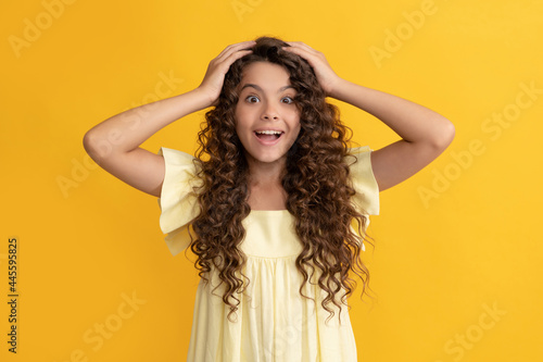 happy teen girl with long curly hair and perfect skin express happiness, healthy hair