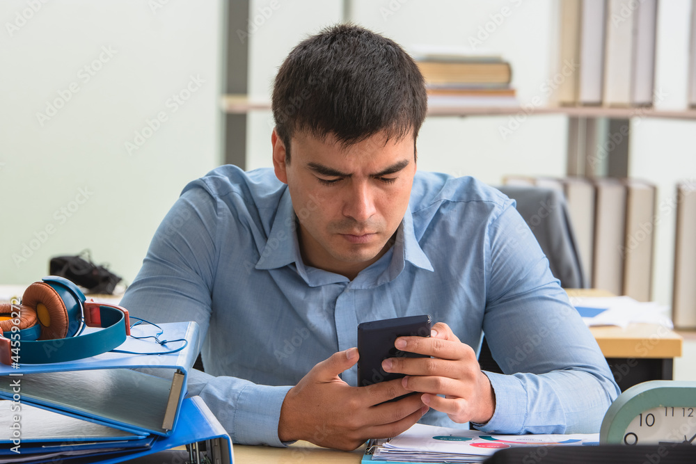 Man using smartphone sitting in office online internet technology Man using smartphone sitting in office online internet technology