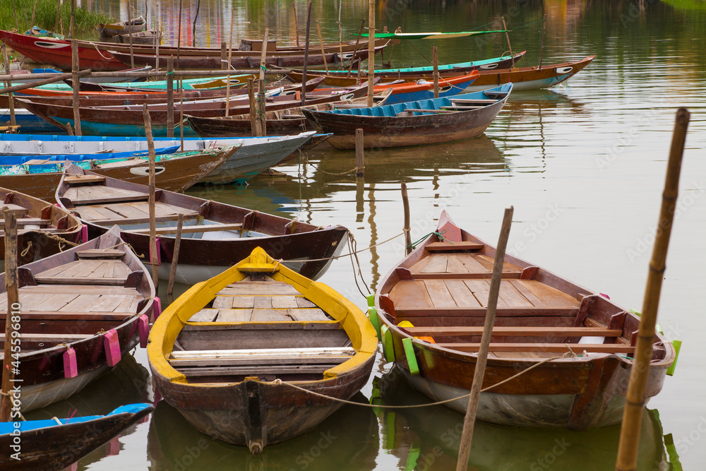 Colorful, old wooden boats sit idle in the river in Hoi An, Vietnam
