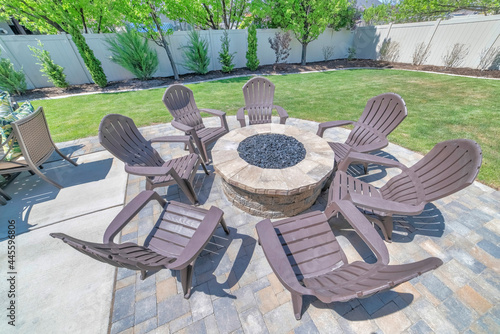 Backyard fire pit made of brick on the deck of a home with chairs set up around it photo