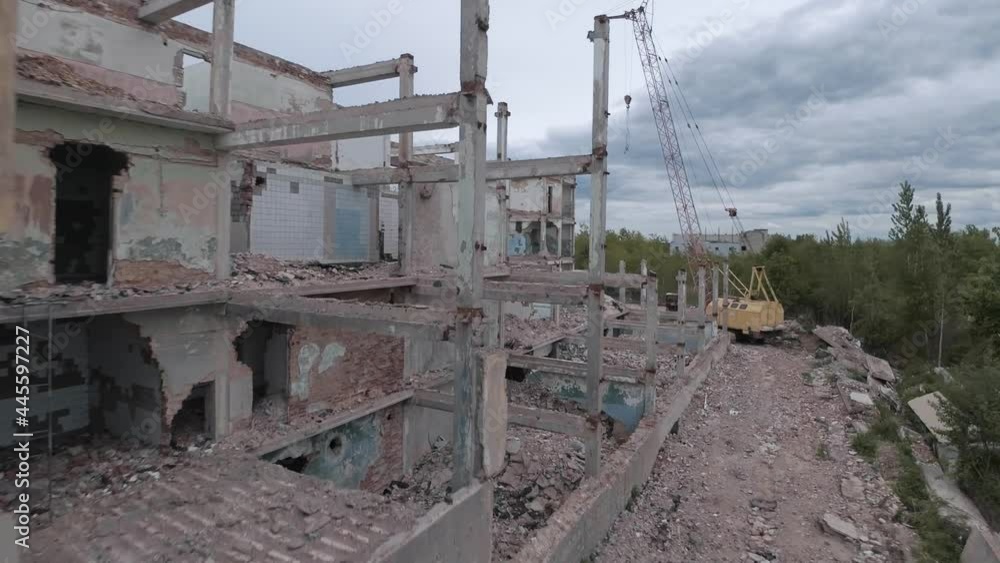 FPV drone flies quickly and maneuverable among abandoned industrial buildings and around an excavator. FPV drone flies quickly and maneuverable among abandoned industrial buildings and around an excavator.