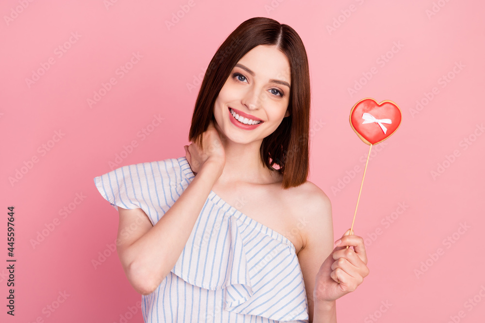 Photo of young girl happy positive smile hold cookies heart figure romantic isolated over pink color background Photo of young girl happy positive smile hold cookies heart figure romantic isolated over pink color background