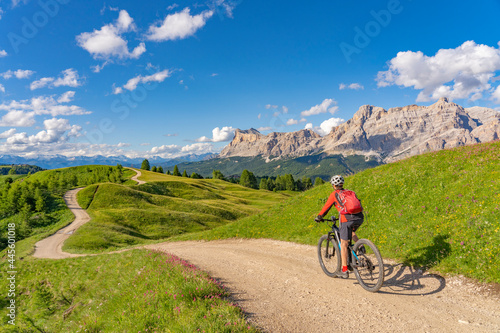 nice and active senior woman riding her electric mountain bike on the Pralongia Plateau in the Alta Badia Dolomites with awesome Sasso die Santa Cruce summit in Backg, South Tirol and Trentino, Italy © Uwe